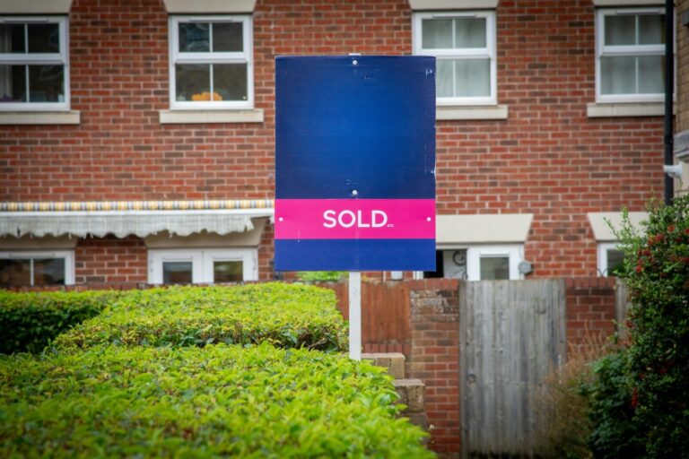 A sold sign in front of a brick building