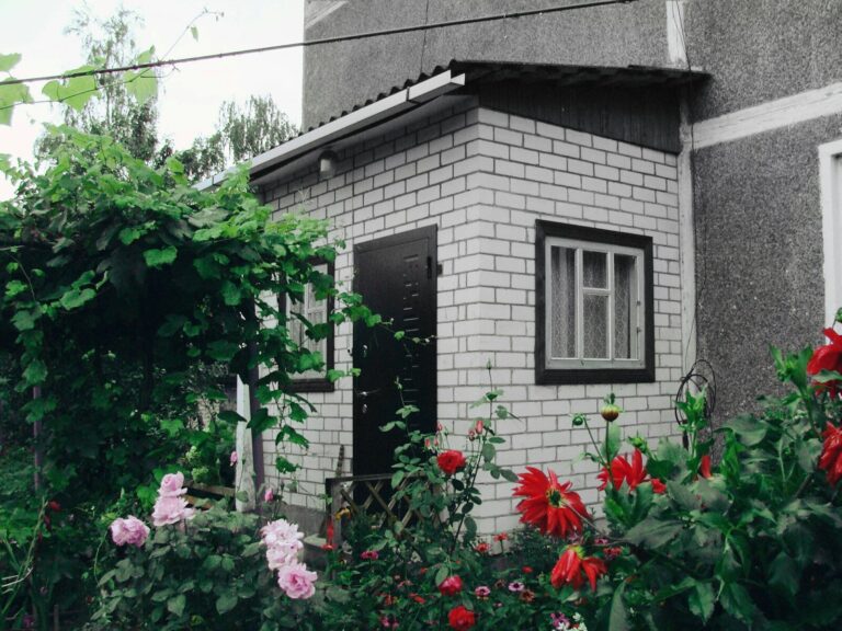 White brick porch with flowers and greenery