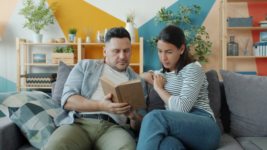 Couple sitting on couch looking at a box